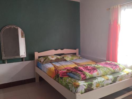 1 dormitorio con 1 cama en una habitación con ventana en MATRONA en Bajawa