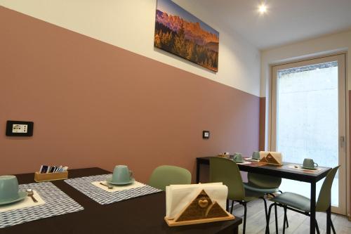 a dining room with a table and green chairs at Abete rosso in Tesero