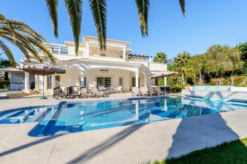 a swimming pool in front of a house at Alcore Luxury Golf Villa at Alto Golf Alvor in Alvor