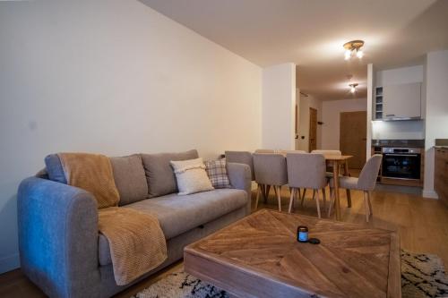 salon z kanapą i stołem w obiekcie Charming three-room apartment in Huez - Welkeys w mieście LʼHuez