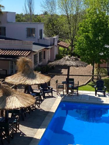 una piscina con sillas y sombrillas junto a un edificio en Cabañas Peumayen en Colón