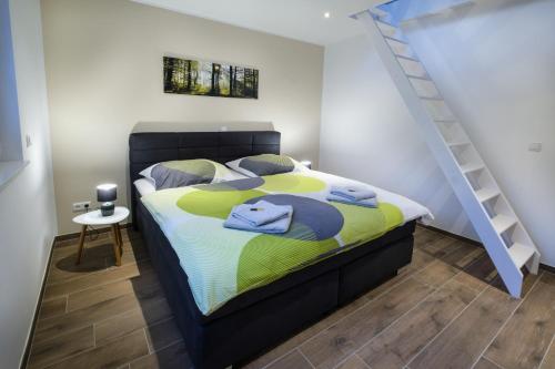1 dormitorio con 1 cama con edredón amarillo y azul en Chalet Terraluna, en Heimbach