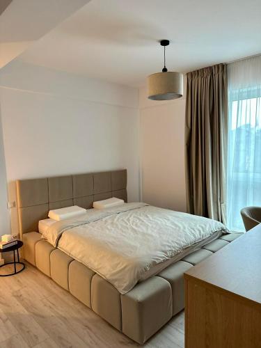 a bedroom with a large bed in front of a window at Balcescu Downtown Apartment in Bistriţa