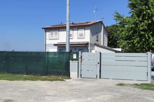 a white fence in front of a white house at Appartamento B&B Cà Betty in Calderara di Reno