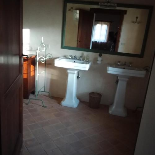 a bathroom with two sinks and a mirror at B&B Casale Ormano in San Venanzo
