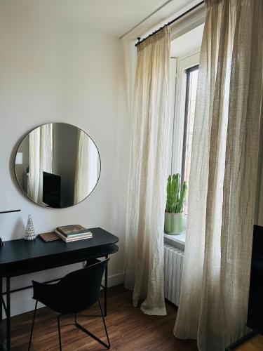 a room with a desk and a mirror and a window at LOFT MANZONI 37 in Cremona