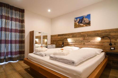 1 dormitorio con 1 cama grande y cabecero de madera en Abete rosso, en Tesero