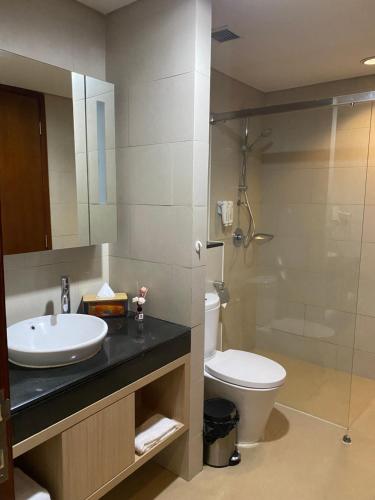 a bathroom with a sink and a toilet and a shower at The H Tower Residence by YLS Stay in Jakarta