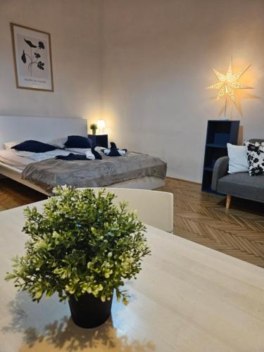 Sala de estar con cama y mesa con planta en Chic Central Rooms, en Budapest