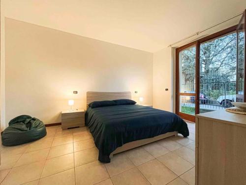 ein Schlafzimmer mit einem Bett und einem großen Fenster in der Unterkunft GG's Home in Seveso
