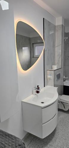 a bathroom with a white sink and a mirror at Lotus 