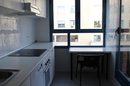 a kitchen with white cabinets and a chair in it at Reverdecer 2 in Madrid