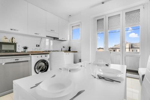 een witte keuken met een tafel en een vaatwasser bij ROG27-Large apartment with transport close to home- in Milaan