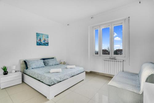 een witte slaapkamer met een bed en een raam bij ROG27-Large apartment with transport close to home- in Milaan