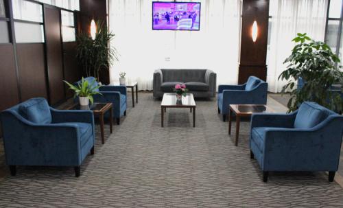 uma sala de espera com cadeiras e mesas azuis em Radisson Hotel Montreal Airport em Ville Saint Laurent