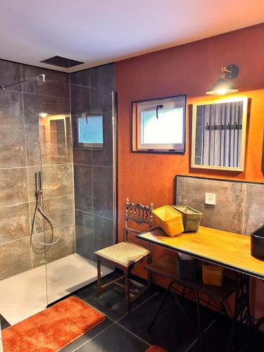 La salle de bains est pourvue d'une douche, d'une table et d'un banc. dans l'établissement La Grange Aux Hirondelles - Chambre Atelier, à Woignarue