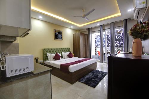 een hotelkamer met een bed en een keuken bij Limewood Stay Silver Studio Apartment Near Golf Course Road in Gurgaon