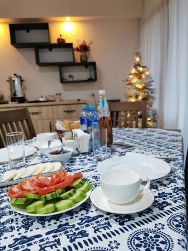 a table with plates of fruit and a christmas tree at Chateau Ateni Cottages in Gori