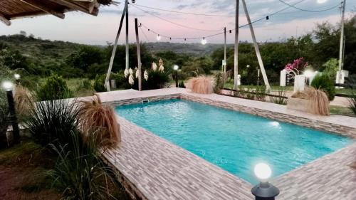 ein Schwimmbad in der Mitte eines Gartens in der Unterkunft El Rincon de Jose Luis - Cabañas y Restaurante in Tanti