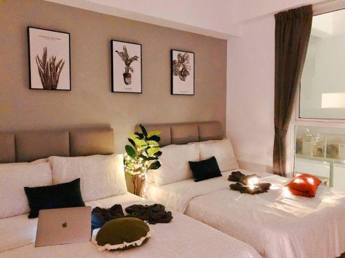 a bedroom with two beds and a laptop on the bed at Space Grey / Opposite IMAGO / KK City Center in Kota Kinabalu