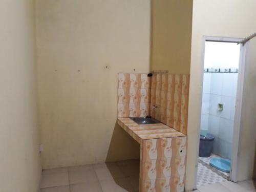uma casa de banho com um lavatório num quarto em Kost Cendana em Kudus
