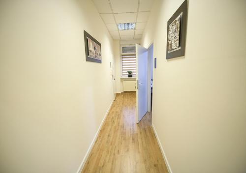 a hallway with white walls and a blue door at GLOW Apartment in Magdeburg