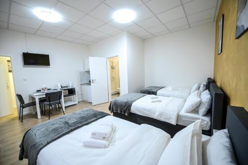 a hotel room with two beds and a desk at GLOW Apartment in Magdeburg