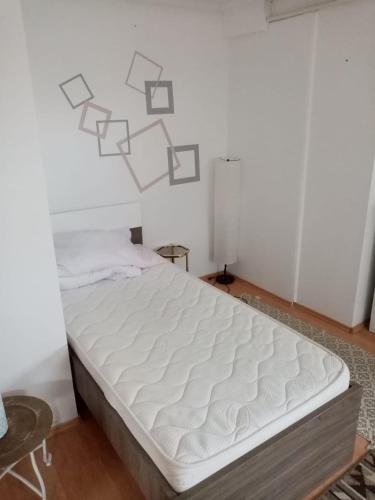 a bed in a room with a white wall at Blueberry Design Studio Koszeg Sleeps 4 in Kőszeg