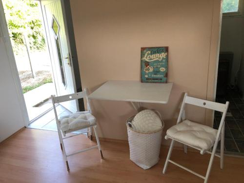 a table and two chairs in a room with a window at Blueberry Design Studio Koszeg Sleeps 4 in Kőszeg