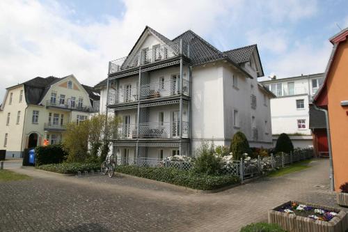 Un grand bâtiment blanc avec balcon se trouve dans une rue. dans l'établissement Stadt Residenz WE2 WE3 WE5 WE 7 - 2, à Bansin