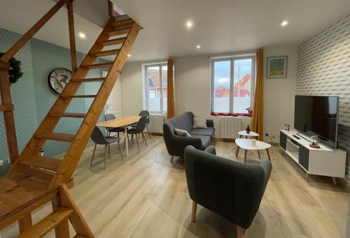 a living room with a staircase and a couch and a table at Gîte Le Duplex - 5min de la gare vers Lille-Lens-Arras in Phalempin
