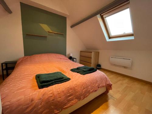a bedroom with a bed with two green towels on it at Gîte Le Duplex - 5min de la gare - Hypercentre in Phalempin