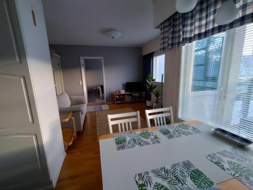 a kitchen and living room with a table and chairs at Viihtyisä kaksio ydinkeskustassa in Lappeenranta