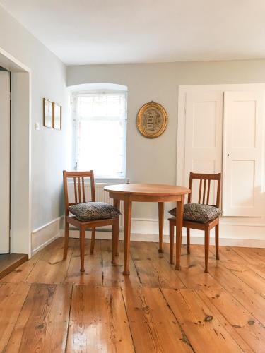 a dining room with a wooden table and two chairs at Fuxbau in Neustadt an der Weinstraße