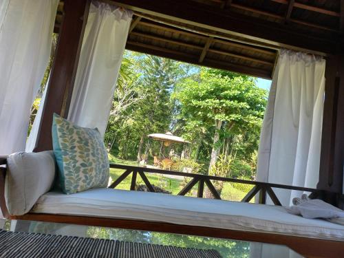 asiento junto a la ventana en una habitación con vistas en Abalone Resort en Candidasa