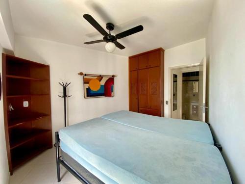a bedroom with a bed and a ceiling fan at APTO DE FRENTE PARA O MAR - CARAGUATATUBA. in Caraguatatuba