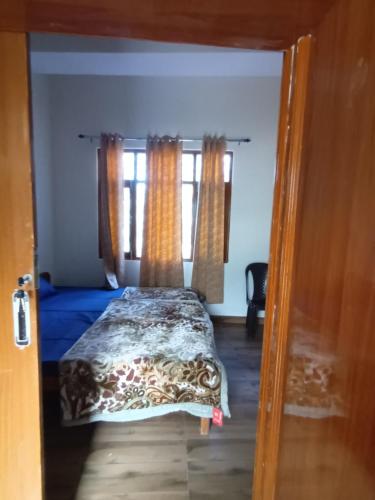 a bedroom with a bed and two windows at Him Aaranya Home stay Shimla in Shimla