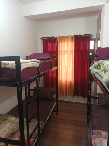 a room with three bunk beds and a window at Him Aaranya Home stay Shimla in Shimla