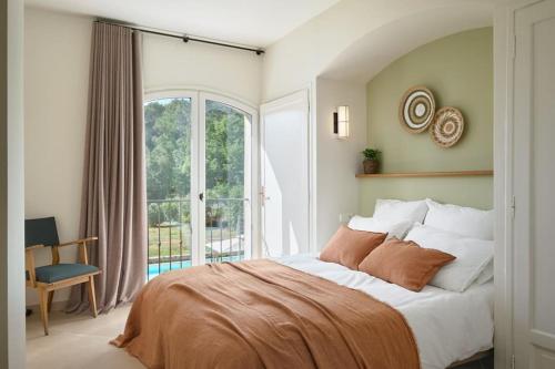 une chambre avec un grand lit et une grande fenêtre dans l'établissement Le clos d'allegre, à La Colle-sur-Loup
