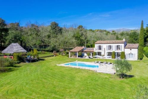 une grande cour avec une maison et une piscine dans l'établissement Le clos d'allegre, à La Colle-sur-Loup