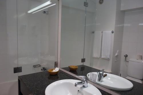 a bathroom with a sink and a toilet and a mirror at Hotel Senhora do Castelo in Mangualde