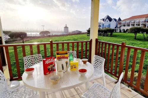 une table blanche et des chaises sur un balcon avec vue dans l'établissement 