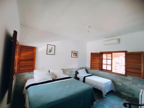 1 dormitorio con 2 camas y ventana en Recanto Rocas, en Pirenópolis