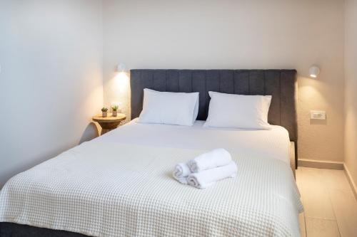 a bedroom with a bed with two towels on it at Kos Infinity Suites in Kos Town