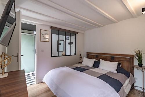 een slaapkamer met een groot bed en een raam bij Le Lodge des Villettes in Jouy-le-Moutier