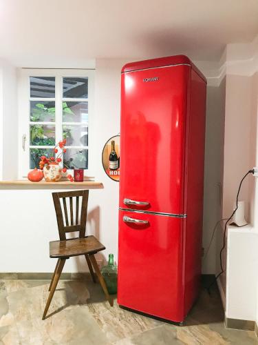 a red refrigerator in a kitchen with a table at Fuxbau in Neustadt an der Weinstraße