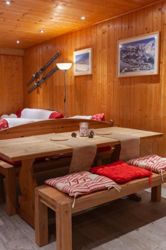 Cette chambre en bois comprend une table et des bancs. dans l'établissement Le Neiger - Appartement Emeraude, à Saint-Martin-de-Belleville