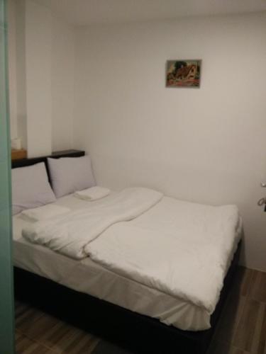 a small bedroom with a bed with white sheets at 7 Hotel in Juru