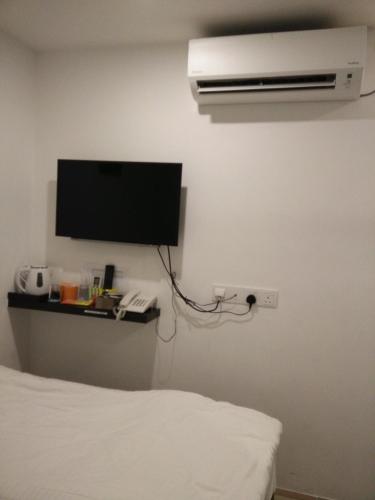 a bedroom with a bed and a tv on the wall at 7 Hotel in Juru