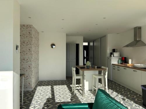 une cuisine et un salon avec une table et un canapé dans l'établissement La Petite Maison des Boettes, à Carpentras